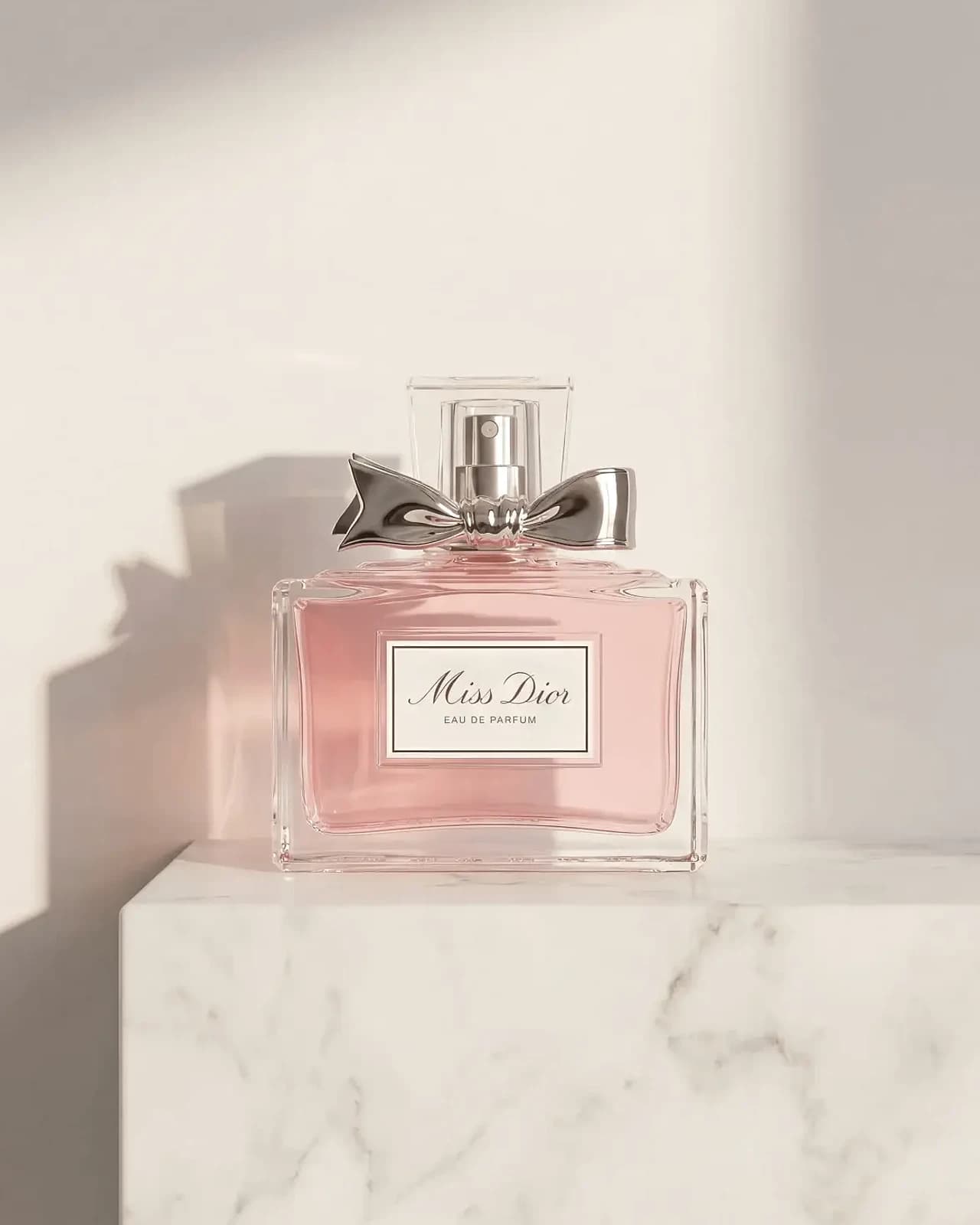 A fragrance bottle on a marble plinth in soft daylight